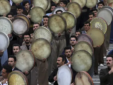 Musisi dari wilayah barat Kurdi Iran memainkan Daf dalam upacara menjelang Tahun Baru Iran, atau Nowruz, di Teheran, Iran (14/3/2022). Nowruz berasal dari setidaknya 1700 SM dan dalam tradisi Zoroaster kuno adalah hari libur paling penting dan diantisipasi dalam budaya Iran. (AP Photo/Vahid Salemi)