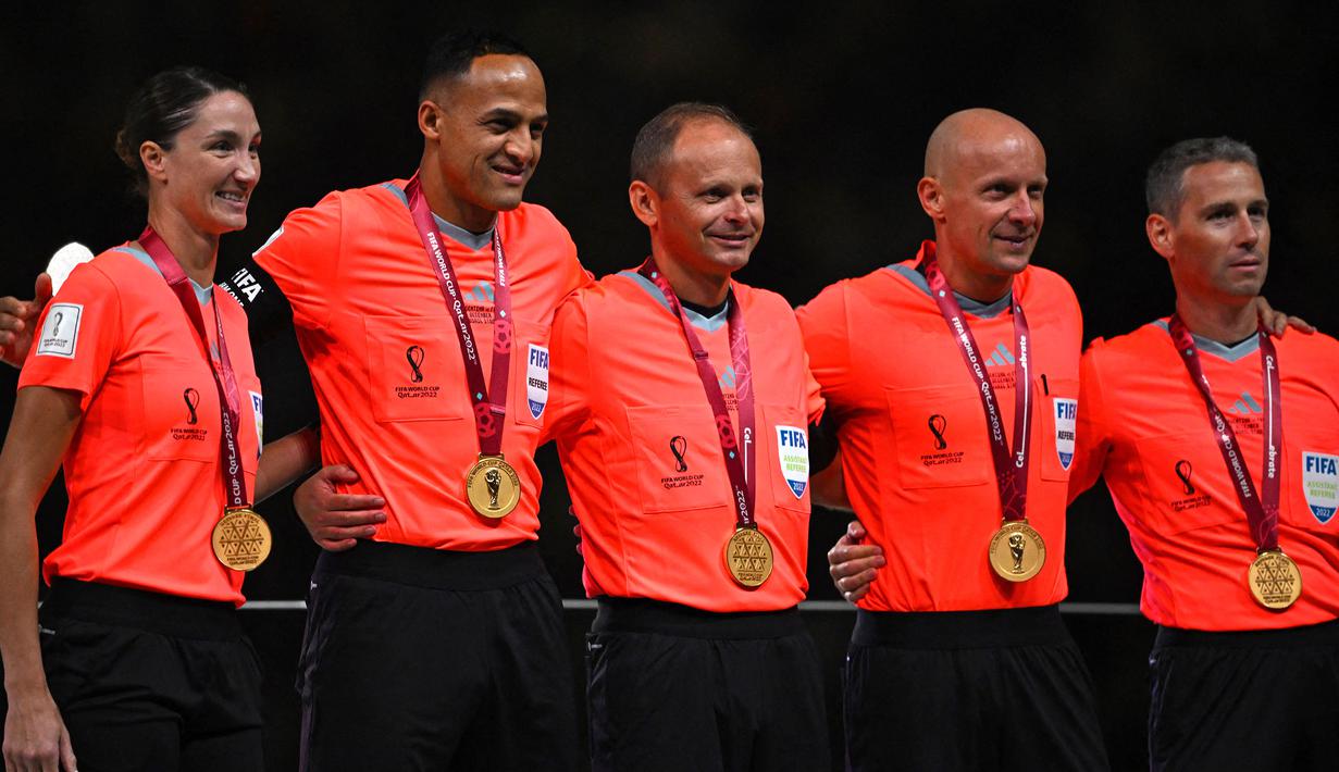 Wasit Szymon Marciniak (kedua kanan) bersama asistennya berfoto bersama saat upacara pemberian trofi setelah laga final Piala Dunia 2022 antara Argentina melawan Prancis di Lusail Stadium, Doha pada 18 Desember 2022. (AFP/Paul Ellis)