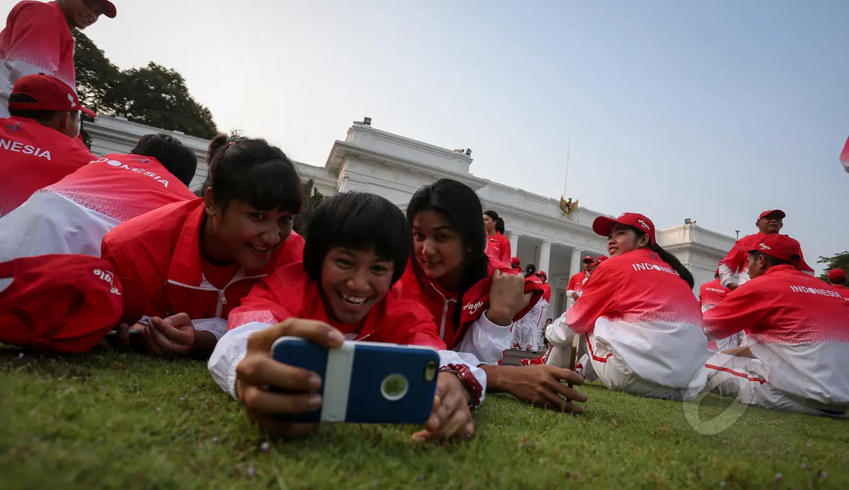Sejumlah atlet berselfie di rumput depan Istana Merdeka, Jakarta, Selasa (26/5/2015). Kontingen Indonesia akan ditemani 226 pelatih dan satu orang Chief de Mission (CdM), dua wakil CdM, serta 32 staf kontingen. (Liputan6.com/Faizal Fanani)
