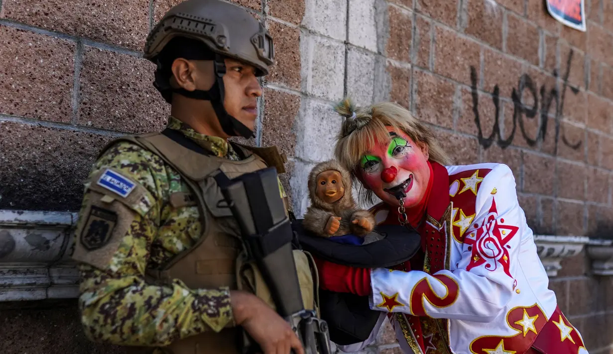 Seorang badut berpose dan berfoto di samping seorang tentara saat parade Hari Nasional Badut Salvador di San Salvador pada tanggal 6 Desember 2023. (Camilo FREEDMAN/AFP)