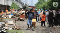 Warga mengangkut barang-barangnya saat penertiban bangunan lokalisasi liar Gunung Antang di Matraman, Jakarta Timur, Selasa (30/8/2022). Sebanyak 120 bangunan liar dibongkar di lahan seluas 2.500 meter persegi milik PT KAI dan selanjutnya akan dijadikan Ruang Terbuka Hijau (RTH). (Liputan6.com/Herman Zakharia)