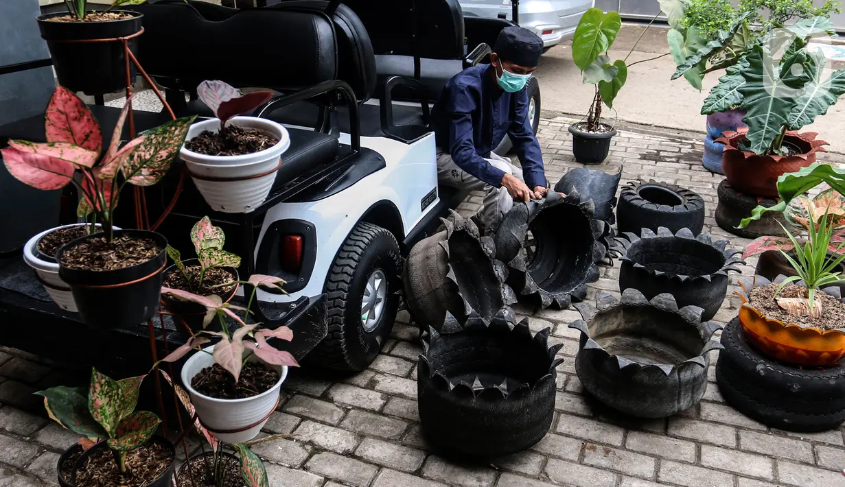Abdul Kholik menyelesaikan pembuatan pot bunga dari ban bekas di Galeri Abdul Kholik, Tapos, Depok, Jumat (30/10/2020). Kerajinan pot bunga dari limbah ban bekas mobil Boogie Car atau mobil golf itu dijual seharga Rp75 ribu hingga Rp100 ribu tergantung warna dan ukuran. (Liputan6.com/Johan Tallo)