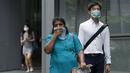 Pekerja memakai masker saat berjalan di pusat bisnis, Singapura (25/9/2015). Menurut Badan Lingkungan Nasional Singapura kabut Polutan Standar Indeks (PSI) mencapai tinggi 341 pada hari Jumat. (REUTERS/Edgar Su)