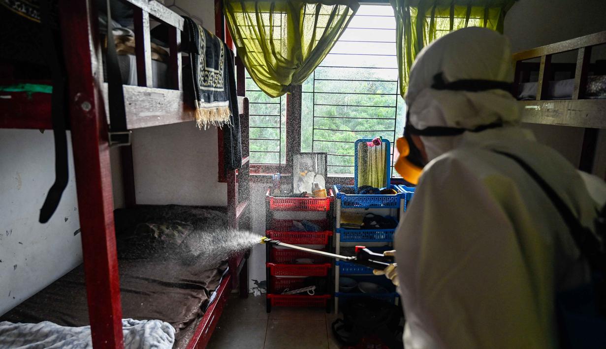 Seorang anggota Badan Penanggulangan Bencana Daerah (BPBD) menyemprotkan disinfektan di sebuah Sekolah Menengah Pertama (SMP) dalam rangka program mitigasi pencegahan penyebaran flu burung di Banda Aceh pada Jumat 31 Oktober 2025. Ini merupakan langkah preventif untuk mencegah potensi penyebaran virus di lingkungan sekolah. (Chaideer MAHYUDDIN/AFP)