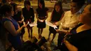Beberapa wanita tampak berkumpul sambil memegangi lilin di kawasan Independence Square, Kuala Lumpur. Mereka menyanyikan lagu-lagu untuk mendoakan para korban Malaysia Airlines MH370 yang berlangsung Senin (10/03/14) malam (REUTERS / Edgar Su) 