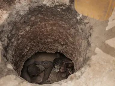 Dua buruh tambang saat mencari batu safir di dalam lubang tanah yang digali di kawasan pertambangan batu safir di Sakaraha, Madagaskar. Batu Safir pertama kali ditemukan di Madagaskar pada akhir 1990-an. (AFP Photo/Gianluigi Guercia)