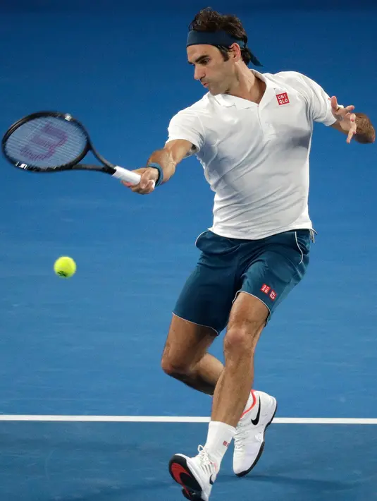 Petenis Swiss, Roger Federer mengembalikan bola ke arah Taylor Fritz dari AS dalam babak 32 besar Australia Terbuka di Melbourne, Jumat (18/1). Federer melaju mulus ke babak 16 besar setelah menang tiga set langsung 6-2 7-5 6-2. (AP/Kin Cheung)