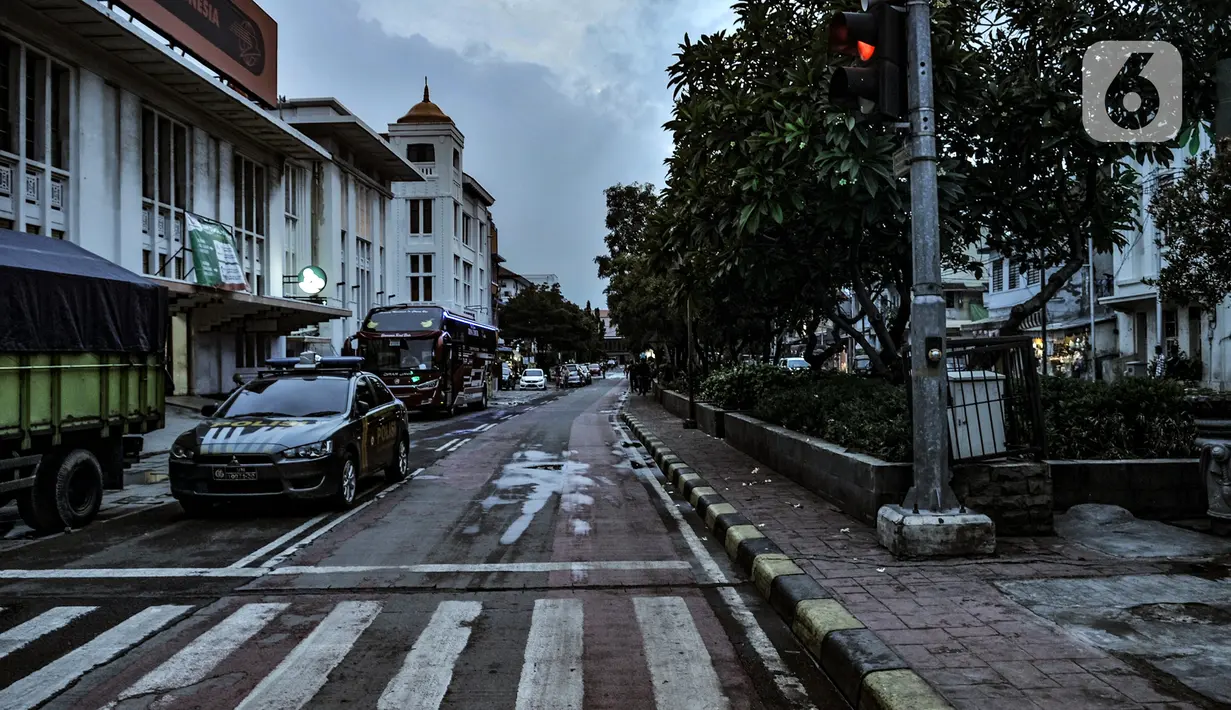 Mobil polisi terparkir di kawasan Kota Tua, Jakarta, Kamis (31/12/2020). Pemprov DKI Jakarta menutup kawasan Kota Tua pada malam Tahun Baru kali ini guna mencegah kerumunan warga sebagai langkah memutus penyebaran COVID-19. (merdeka.com/Iqbal S. Nugroho)
