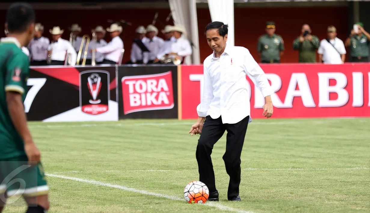 Presiden Joko Widodo menendang bola ke arah pemain PSS saat pembukaan turnamen Piala Presiden 2017 di Stadion Maguwoharjo, Sleman, Sabtu (4/2). 31.000 penonton menyaksikan laga pembuka turnamen Piala Presiden 2017. (Liputan6.com/Helmi Fithriansyah)