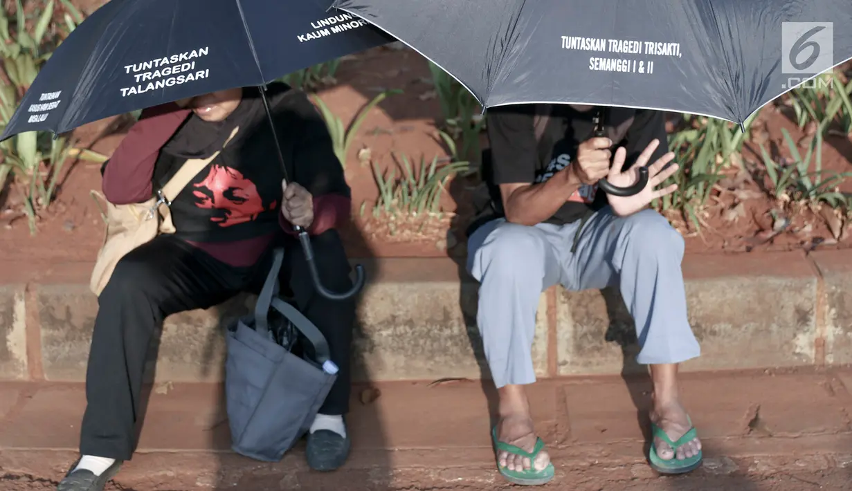Massa Jaringan Solidaritas Korban untuk Keadilan (JSKK) beristirahat saat menggelar aksi Kamisan di depan Istana Negara, Jakarta, Kamis (30/8). JSKK menuntut pemerintah menyelesaikan kasus pelanggaran HAM berat masa lalu. (Liputan6.com/Immanuel Antonius)