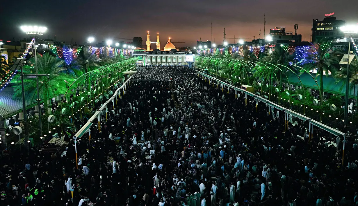 Umat muslim Syiah berkumpul di sekitar tempat suci Imam Husein (belakang) pada hari pertama Idul Adha di Karbala, Irak, 9 Juli 2022. Umat muslim seluruh dunia merayakan Idul Adha atau Hari Raya Kurban untuk memperingati kesediaan Nabi Ibrahim mengorbankan putranya. (AP Photo/Hadi Mizban)
