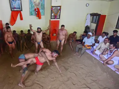 Pegulat beraksi dalam pertandingan gulat tradisional di klub gulat Loknath Vyayamsala di Prayagraj, India, (21/8/2023). Acara tersebut untuk merayakan festival Hindu Nag Panchami. (AFP/Sanjay kanojia)