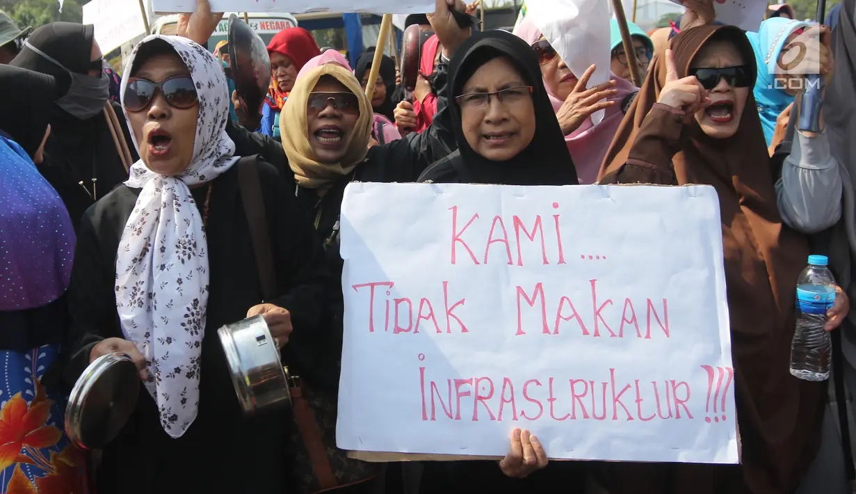 Sejumlah ibu-ibu yang tergabung dalam Barisan Emak-Emak Militan (BE2M) Indonesia menggelar aksi di seberang Istana Merdeka, Jakarta, Rabu (18/7). Mereka menuntut Presiden Jokowi menurunkan harga sembilan bahan pokok (sembako). (Liputan6.com/Arya Manggala)
