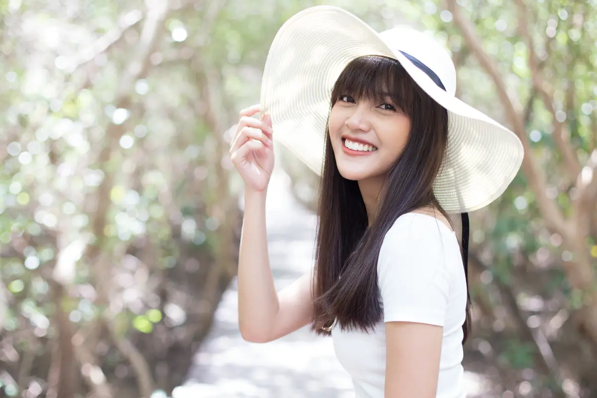 tersenyum memakai topi