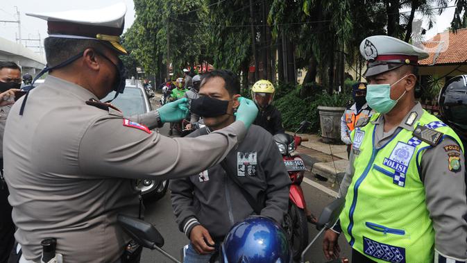 Petugas memakaikan masker ke pengendara saat kegiatan Check Point Pengawasan Pelaksaanaan PSPBB di kawasan Pasar Jumat, Jakarta selatan, Jumat (10/4/2020). Kegiatan gabungan Dishub dan Polda Metro Jaya merupakan Pergub Nomor 33 Tahun 2020 tentang Pelaksanaan PPSB. (merdeka.com/Arie Basuki)