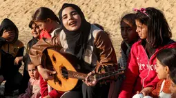 Ruaa Hassouna berusaha menghibur anak-anak penyintas perang Hamas-Israel. (SAID KHATIB/AFP)