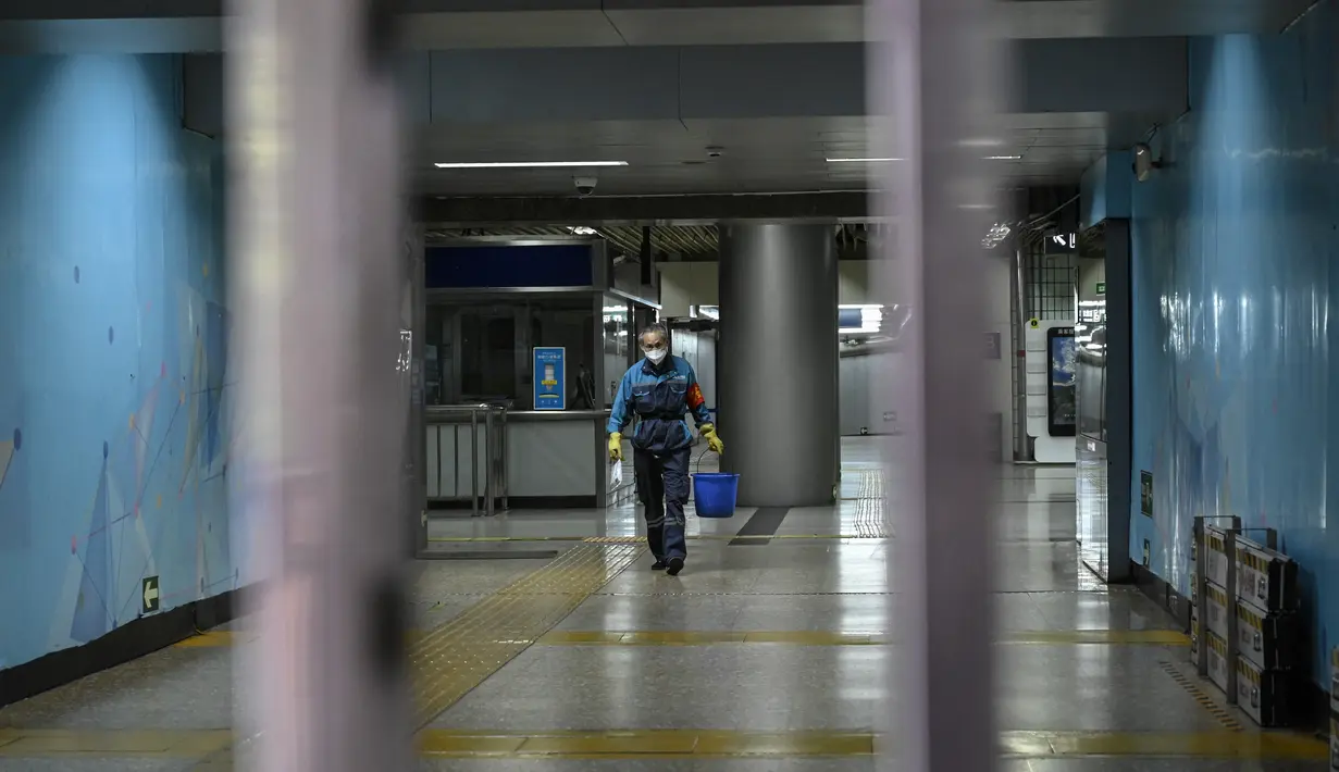 <p>Seorang petugas kebersihan terlihat di stasiun kereta bawah tanah yang ditutup di kawasan pusat bisnis di Beijing, Rabu (4/5/2022). Beijing pada hari Rabu ini menutup lebih dari 40 stasiun kereta bawah tanah, sekitar sepersepuluh dari jaringan kereta, sebagai bagian dari tindakan untuk menghentikan penyebaran Covid-19. (Giok GAO / AFP)</p>