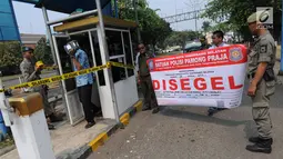 Petugas Satuan Polisi Pamong Praja (Satpol PP) Kota Tangerang Selatan memasang spanduk penyegelan areal parkir liar di kawasan BSD, Rabu (3/10). Penyegelan tersebut dilakukan lantaran pihak pengelola parkir tidak memiliki izin. (Merdeka.com/Arie Basuki)