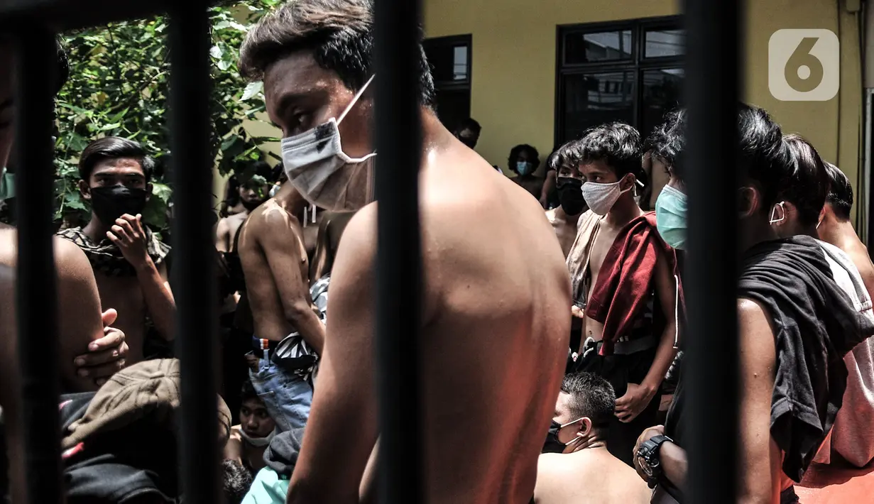 Massa pelajar dan remaja ditahan pihak kepolisian di Polsek Subsektor Palmerah, Jakarta, Kamis (8/10/2020). Mereka diringkus pihak kepolisian saat hendak menuju gedung DPR RI untuk mengikuti aksi menolak RUU Cipta Kerja bersama massa buruh dan mahasiswa. (merdeka.com/Iqbal Nugroho)