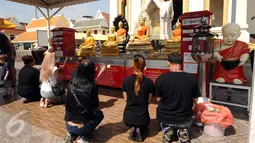 Pengunjung berdoa di kawasan kuil Golden Budha di kota Bangkok, Thailand, Sabtu (17/12). Salah satu biksu yang ada di kuil tersebut memprediksi hasil laga final kedua Piala AFF 2016 antara Thailand melawan Indonesia. (Liputan6.com/Helmi Fithriansyah)