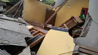 Seorang pria berdiri di antara reruntuhan rumah setelah gempa tektonik berkekuatan magnitudo 6,4  mengguncang Lombok, Sumbawa, dan Bali, Minggu (29/7). (HO/NUSA TENGGARA BARAT DISASTER MITIGATION AGENCY/AFP)