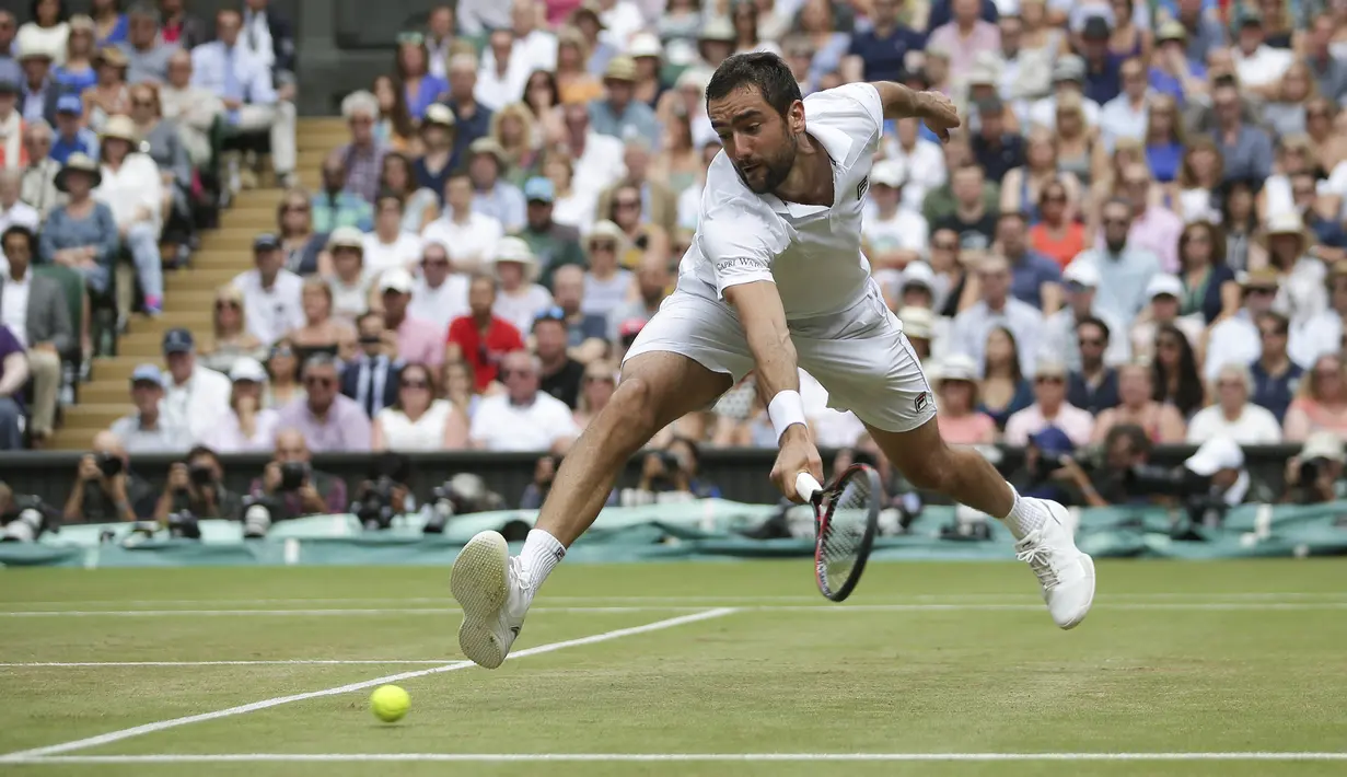 Petenis Kroasia, Marin Cilic, berusaha mengembalikan bola saat pertandingan melawan petenis Swiss, Roger Federer pada laga final Wimbledon 2017 di London, Minggu (16/7/2017). Federer menang 6-3, 6-1, 6-4 atas Cilic. (AFP/Daniel Leal-Olivas)
