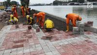 Petugas memasang konblok di pinggir Danau Sunter, Jakarta Utara, Senin (19/2). Progres penataan Danau Sunter telah mencapai 70 persen dan menargetkan penataan rampung sebelum pelaksanaan Festival Danau Sunter. (Liputan6.com/Arya Manggala)