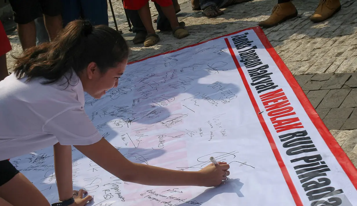 Para demonstran menandatangi petisi yang telah disiapkan sebagai wujud penolakan terhadap RUU Pilkada, Jakarta, Minggu (21/9/2014) (Liputan6.com/Faizal Fanani)