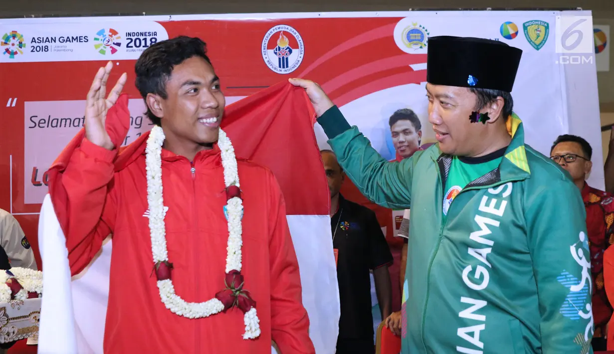 Pelari muda Indonesia, Lalu Muhammad Zohri (kiri) bersama Menpora Imam Nahrawi saat penyambutan di Terminal 3 Bandara Soetta, Tangerang, Selasa (17/7). Lalu M Zohri meraih emas lari 100m di Kejuaraan Dunia U-20 IAAF. (Liputan6.com/Helmi Fithriansyah)