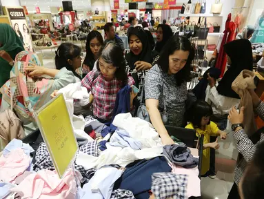 Pengunjung berebut pakaian pada pembukaan Centro Department Store di Pesona Square Depok, Kamis (20/12). Menjelang libur natal dan tahun baru, masyarakat mulai berburu diskon. (Liputan6.com/Fery Pradolo)
