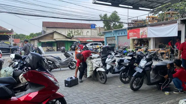 Seorang kurir paket tengah bersiap mengirimkan barang ke tiap rumah tujuan. (Liputan6/Nadia Anatasya)