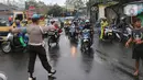 Petugas kepolisian mengatur lalu lintas saat melakukan penutupan jalan KH Hasyim Ashari, Kota Tangerang, Banten, Sabtu (16/7/2022). Akibat banjir yang merendam kawasan tersebut membuat petugas harus menutup jalur dan memutarbalikan para pengendara yang melintas. (Liputan6.com/Angga Yuniar)