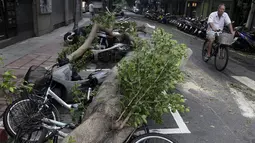 Warga melewati pohon yang tumbang dan menimpa sepeda motor akibat diterjang Topan Dujuan di Taipei, Taiwan, Selasa (29/9/2015). 24 orang mengalami cedera akibat topan raksasa Dujuan. (REUTERS/Pichi Chuang)
