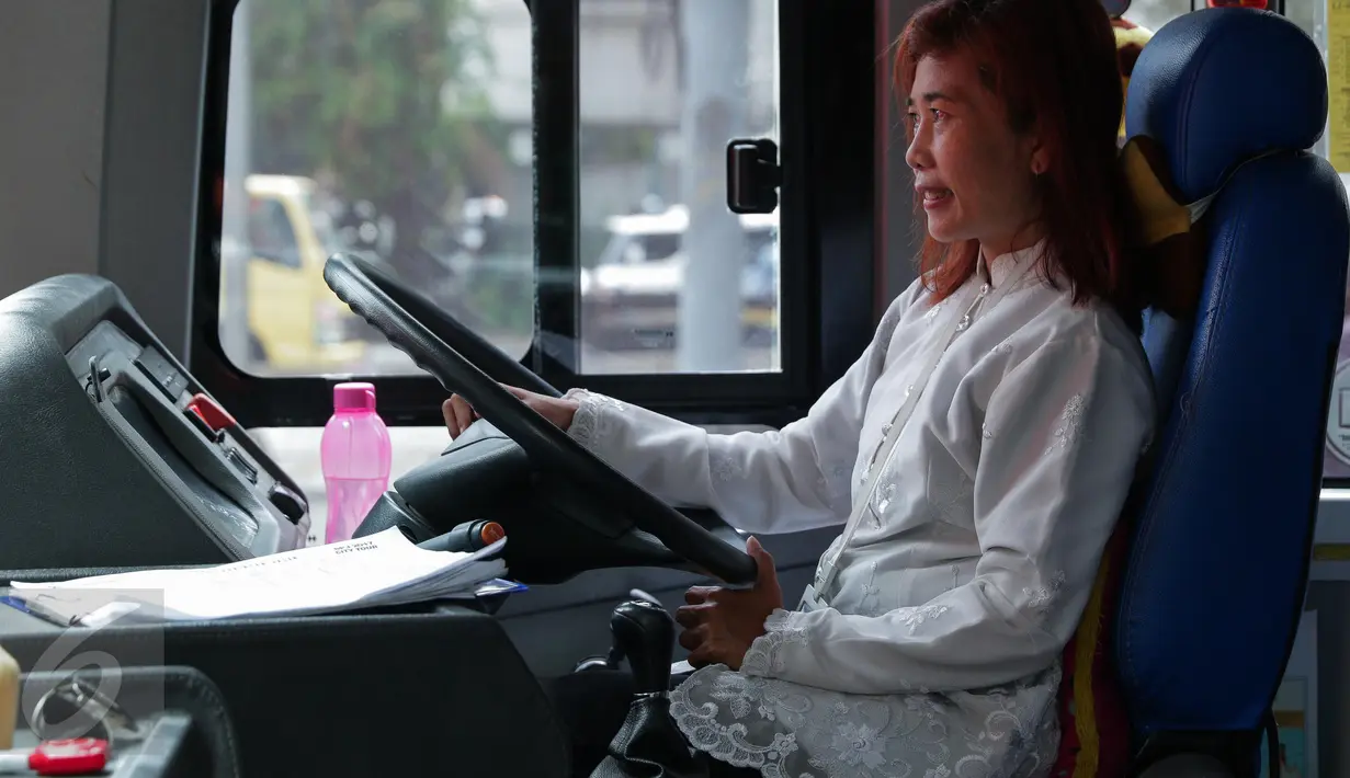 Seorang pramudi mengenakan kebaya saat mengendarai bus tingkat wisata TransJakarta di Jakarta, Jumat (21/4). Dalam rangka Hari Kartini, semua pramudi perempuan bus pariwisata dan Transjakarta mengenakan kebaya. (Liputan6.com/Faizal Fanani)