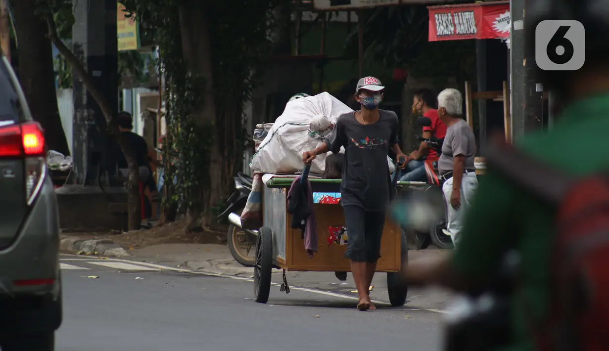 Pemulung melintas di Jalan Raden Saleh, Jakarta, Kamis (30/4/2020). Setiap Ramadan tiba, kemunculan pemulung yang membawa gerobak marak terjadi. Saat ini, kemunculan mereka menjadi masalah tersendiri di tengah upaya memutus mata rantai penyebaran Covid-19. (Liputan6.com/Helmi Fithriansyah)