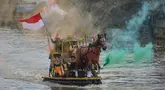 Peserta berparade dengan perahu yang terbuat dari sampah daur ulang mengikuti Festival Perahu Cilung 2025 di kawasan jalan Inspeksi Kali Ciliwung, Pancoran, Jakarta Selatan, Minggu (28/9/2025). (merdeka.com/Arie Basuki)