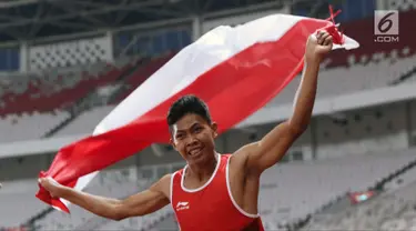 Atlet para-atletik Indonesia, Sapto Yogo Purnomo merayakan kemenangan lari nomor 100 meter T37 pria yang digelar di Stadion GBK, Jakarta, Selasa (9/10). Ini menjadi medali emas kedua Sapto di Asian Para Games 2018. (Liputan6.com/Helmi Fithriansyah)