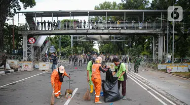 Petugas kebersihan membersihkan sampah sisa pendemo usai unjuk rasa buruh di kawasan Patung Kuda, Jakarta, Kamis (22/10/2020). Sebelumnya, buruh dari berbagai elemen berunjuk rasa menolak pengesahan Omnibus Law UU Cipta Kerja. (Liputan6.com/Faizal Fanani)