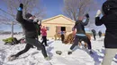 Sarah Hinchcliffe (kiri) mengikuti kelas Yoga Salju bersama Alpaca di salju di Brae Ridge Farm and Sanctuary dekat Guelph, Ontario, pada 20 Februari 2022. Selusin orang mengikuti kelas yoga di luar ruangan dikelilingi oleh alpaca di musim dingin Kanada yang membekukan. (Geoff Robins / AFP)