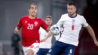 Pemain Denmark, Yussuf Poulsen, berebut bola dengan pemain Inggris, Eric Dier, pada laga UEFA Nations League di Stadion Parken, Rabu (9/9/2020). Kedua tim bermain imbang 0-0. (Liselotte Sabroe/Ritzau Scanpix via AP)