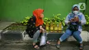 Dua perempuan beristirahat seusai antre membeli minyak goreng di Polsek Tebet, Jakarta Selatan, Jumat (4/3/2022). Polres Metro Jakarta Selatan akan menggelar operasi pasar minyak goreng selama enam hari, terhitung mulai hari in, 4 hingga 9 Februari mendatang. (Liputan6.com/Herman Zakharia)
