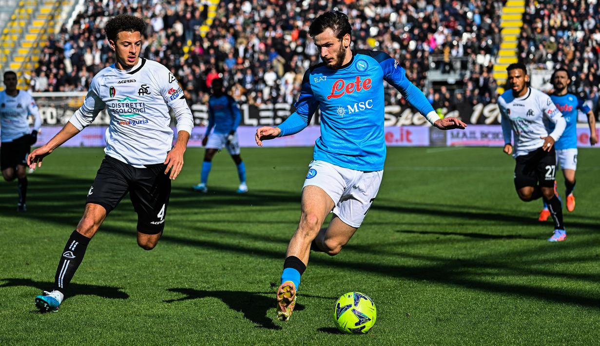 Pemain Napoli, Khvicha Kvaratskhelia (kanan) berebut bola dengan pemain Spezia, Ethan Ampadu pada laga lanjutan Liga Italia 2022/2023 di Alberto-Picco stadium, La Spezia, 5 Februari 2023. Kedatangan Kvaratskhelia pada awal musim benar-benar membuat banyak perubahan bagi skuad Napoli. Ia menjadi pemain yang tajam nan kreatif sebagai seorang winger. Pria berkebangsaan Georgia tersebut bisa disebut sebagai salah satu pembelian terbaik transfer musim panas Eropa 2022. (AFP/Alberto Pizzoli)