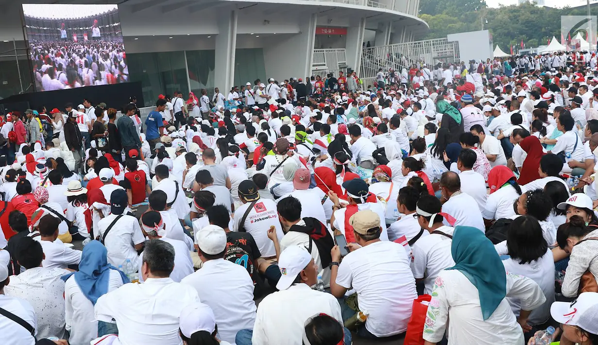 Massa pendukung paslon nomor urut 01 menggelar nonton bareng Konser Putih Bersatu di luar Stadion GBK, Jakarta, Sabtu (13/4). Tingginya antusiasme warga menghadiri kampanye akbar Jokowi-Ma'ruf Amin membuat SUGBK penuh hingga warga terpaksa menonton dari luar stadion. (Liputan6.com/Immanuel Antonius)