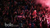 Aremania menyalakan flare usai timnya menang 1-0 atas Sriwijaya FC pada babak delapan besar Piala Presiden 2017 di Stadion Manahan, Solo. Jumat (26/2/2017). (Bola.com/Nicklas Hanoatubun)