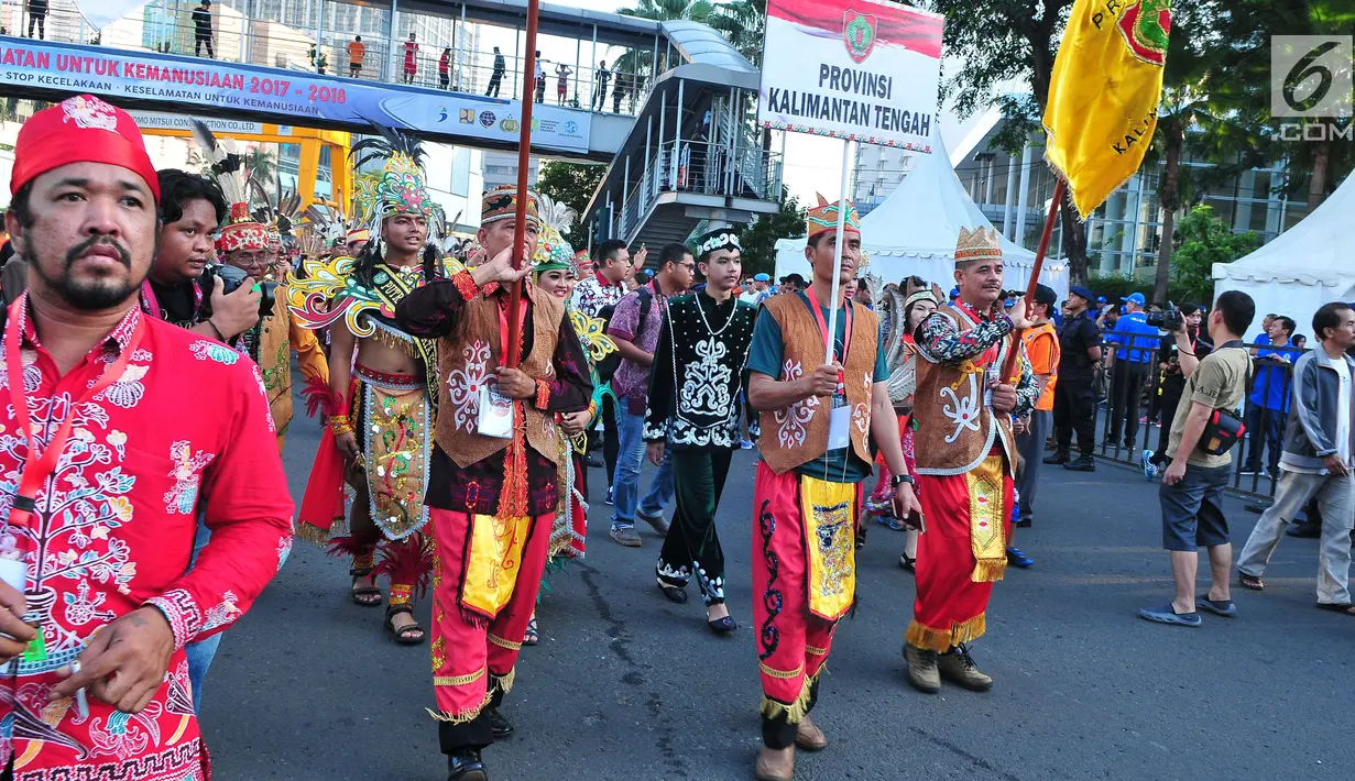 Sejumlah orang mengenakan pakaian adat melakukan pawai festival Budaya Borneo di Car Free Day, Jakarta, Minggu (30/7). Festival tersebut dalam rangka mengenalkan adat dan budaya borneo melalui pakaian dan musiknya. (Liputan6.com/Helmi Afandi)