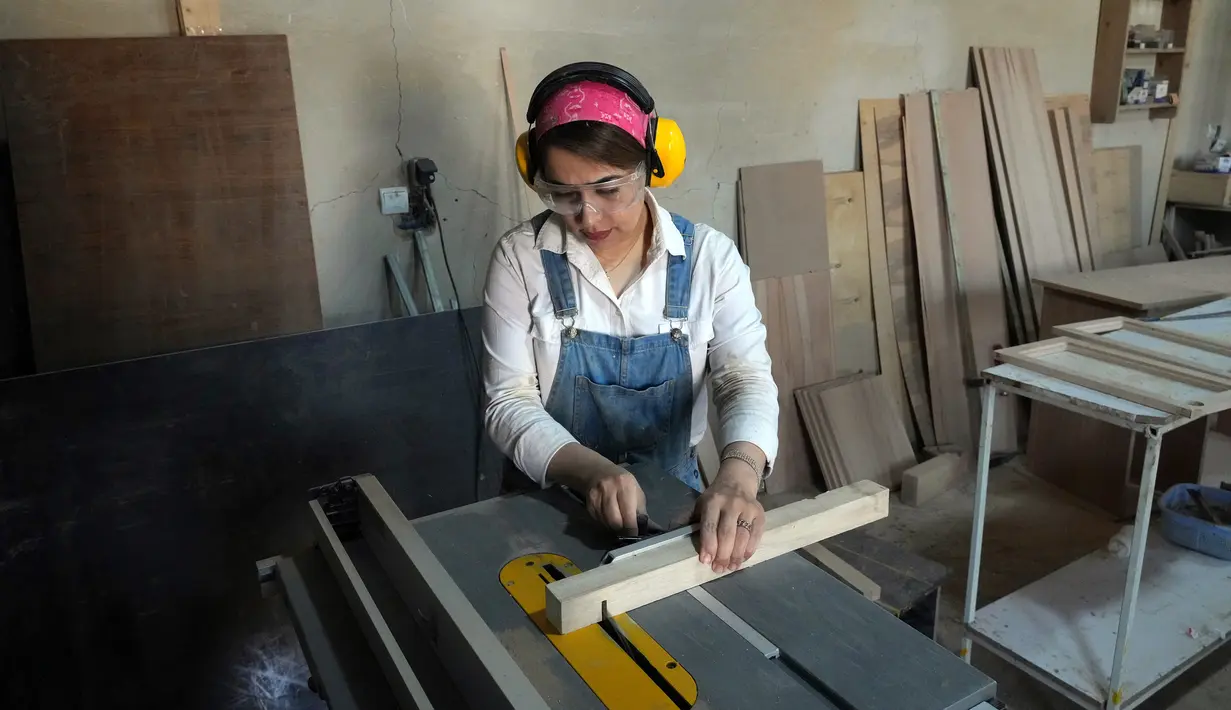 Tukang kayu Iran Sahar Biglari memotong sebatang kayu saat bekerja di bengkelnya di Teheran, Iran, 12 Maret 2023. Semakin banyak perempuan Iran berjuang untuk mengatasi hambatan gender. (AP Photo/Vahid Salemi)