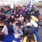 Komunitas Dinding menggelar pendidikan untuk anak-anak putus sekolah di pasar (Liputan6.com/Yoseph Ikanubun)