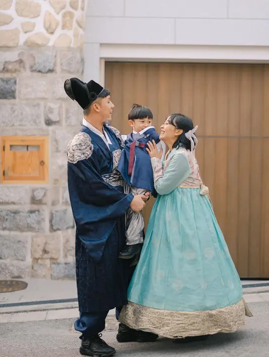 Sementara suami dan putranya kompak kenakan hanbok warna biru dongker dan topi Gat, khas pangeran di drama Korea. @rinni_w.