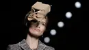 Model mengenakan busana rancangan Moschino dengan hiasan kepala berbentuk sampah kardus dalam Milan Fashion Week Autumn/Winter 2017 di Milan, Italia, (23/2). (AFP Photo / Marco Bertorello)