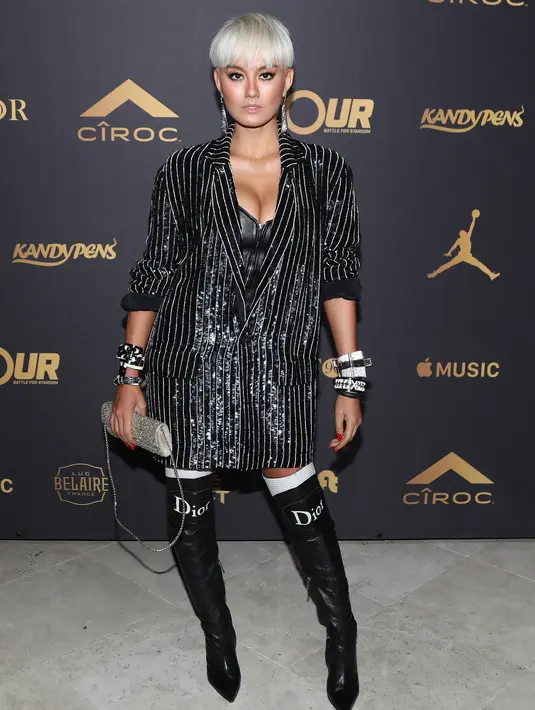 Penampilan Agnez Mo di karpet merah pesta ulang tahun ke-42 DJ Khaled di Los Angeles, 2 Desember 2017. Agnez menyempurnakan gayanya dengan boots tinggi Christian Dior, clutch bling-bling dan gelang ukuran besar. (Jerritt Clark/Getty Images for Ciroc/AFP)